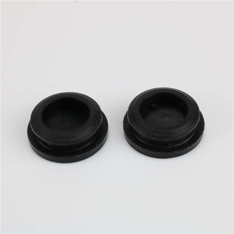 Two black hollow round plugs showing recessed centres and flange edges