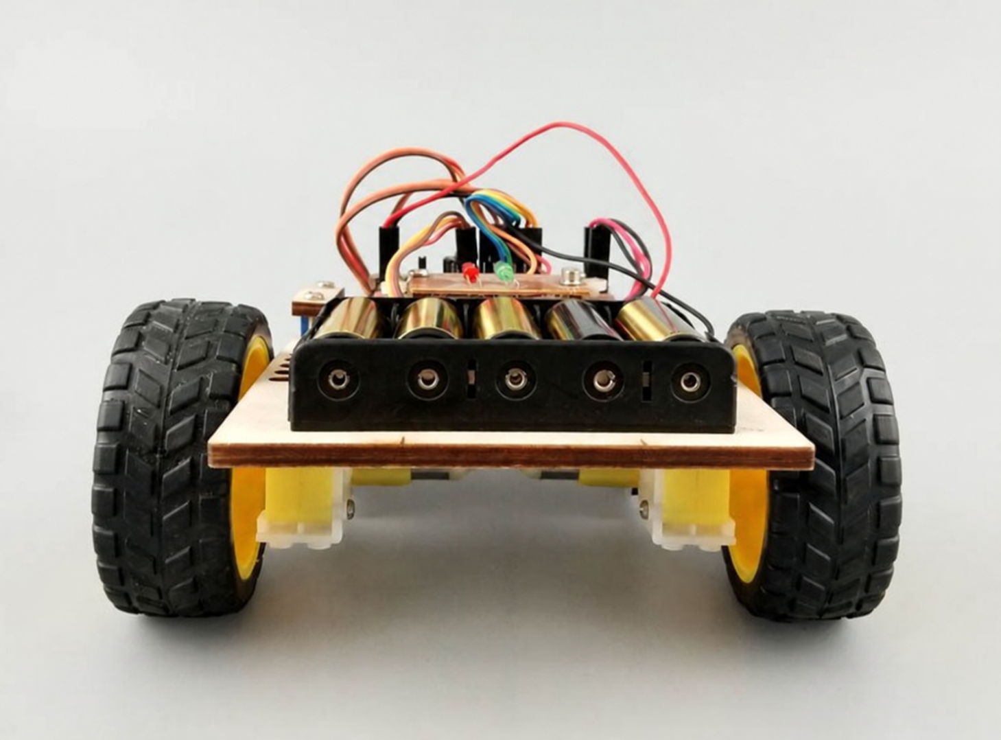 Robot chassis with black rubber wheels, yellow gearmotors and a battery holder