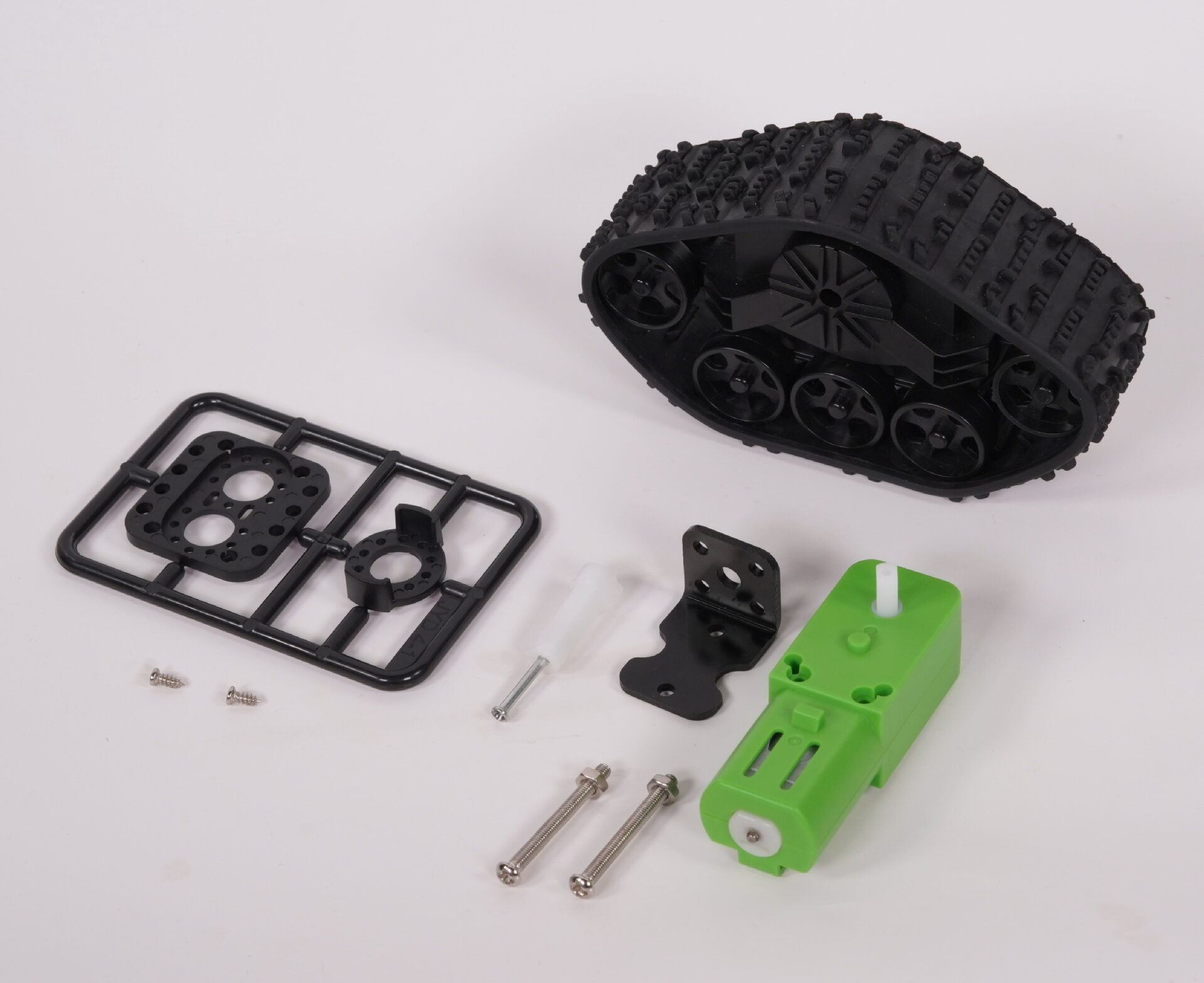 Black robot track, green gearmotor and mounting components arranged on a white background