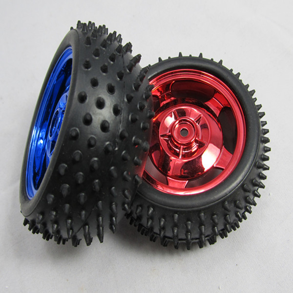 Two studded rubber tyres with blue and red wheel hubs