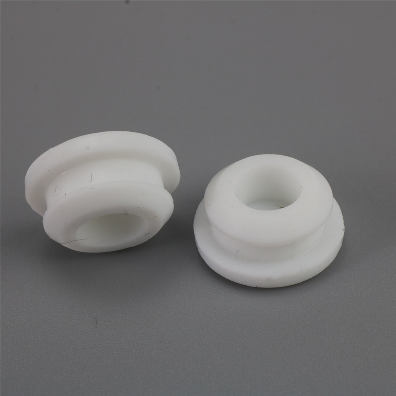 Two white hollow plugs with round flanges